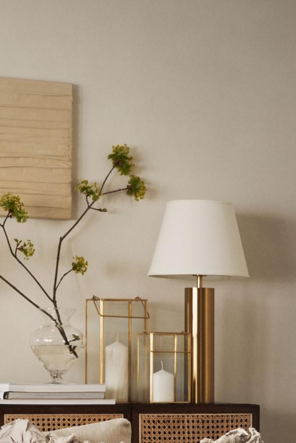 Distribuir piezas pequeñas y doradas por estanterías o repisas añade un toque de lujo vintage a cualquier estancia. Si además lo combinas con algún mueble que tenga rejilla, como ves en la imagen, la mezcla no podía ser más cálida y agradable. Portavelas de metal de H&M Home (17,99 euros).
