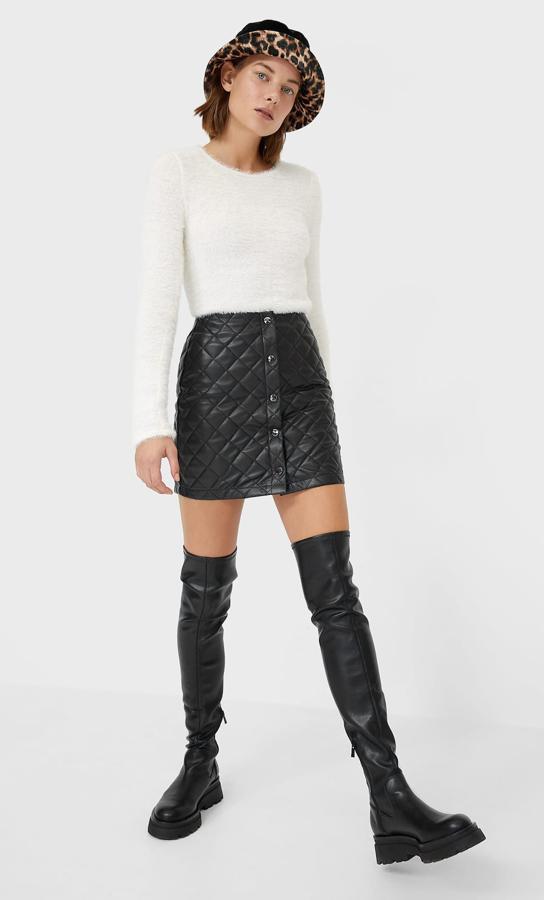 En color negro, esta falda mini de efecto piel con detalle cosido en diamante cuenta con cierre frontal con botones y tiene un precio rebajado de 13,99 euros.