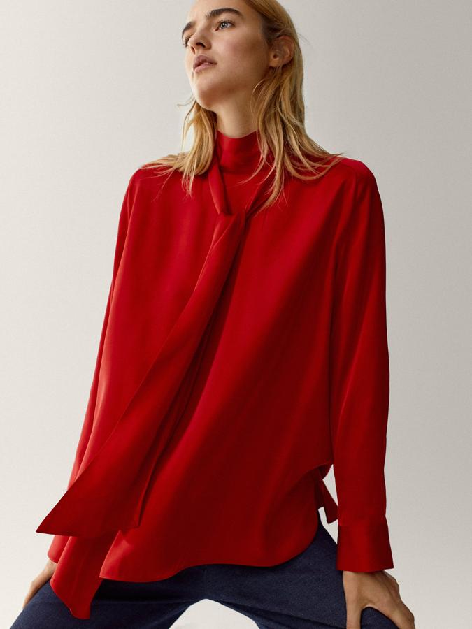 Cuello con detalle de lazada y cierre de botón en la parte posterior, esta camisa en rojo intenso, de corte recto y bajo con aberturas laterales costaba 49,95 euros y ahora podemos comprarla por 29,95 euros entre las tallas 34 y 42.