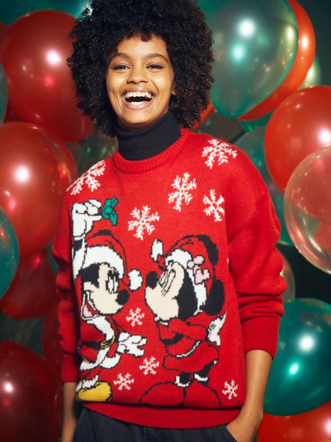 De corte holgado, con cuello redondo y mangas largas, este jersey de punto con acabados con ribete de canalé en cuello, puños y bajo viene con estampado de Mickey y Minnie y copos de nieve, todo ello en color rojo. Cuesta 19,99 euros y está disponible entre las tallas S y XL.