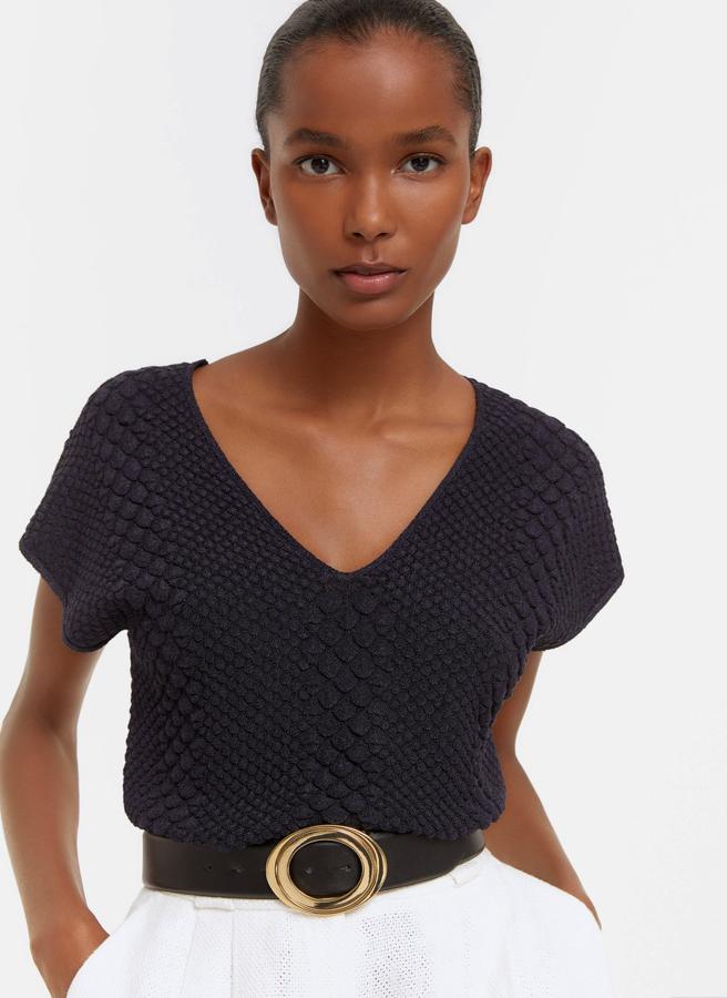 Disponible en beige o en negro, este top de punto con relieve viene con escote de pico en delantero y espalda, mangas sisa y tira en la espalda. Podemos encontrarlo en las tallas S, M y L y de 59 euros ha pasado a costar 44,25.