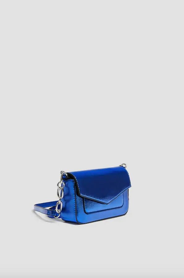 Esta bandolera con cierre de solapa y bolsillo en la parte frontal en azul metalizado es de Pull&Bear y viene con asa de hombro en combinación de materiales. Cuesta 12,99 euros.