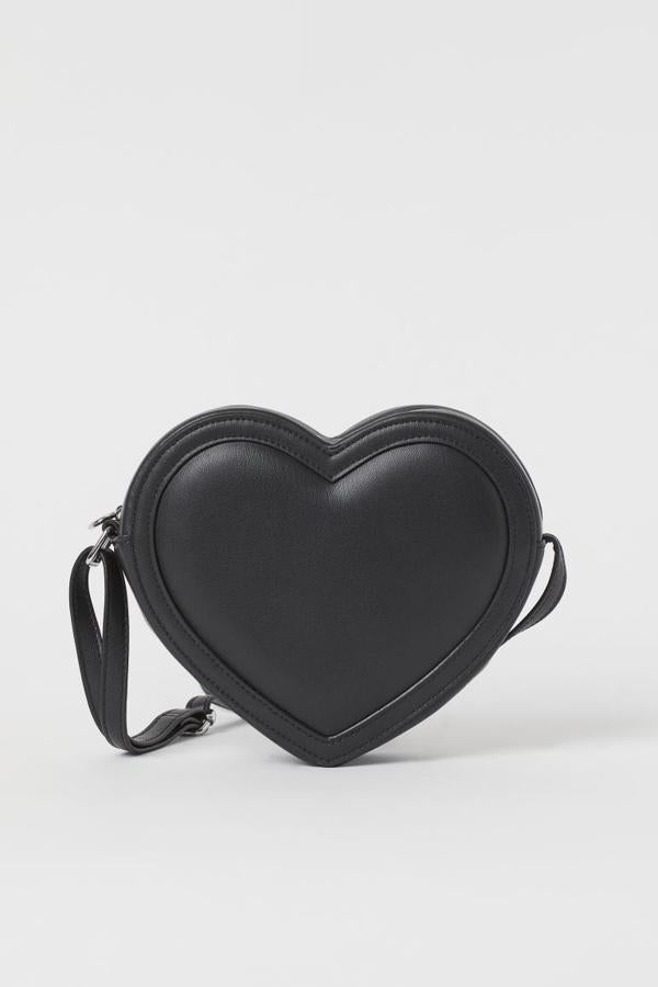 En negro y con forma de corazón, este bolso en piel sintética acharolada y ante sintético de H&M vienen con correa ajustable y cierre de cremallera acabada también en corazón. Cuesta 14,99 euros.