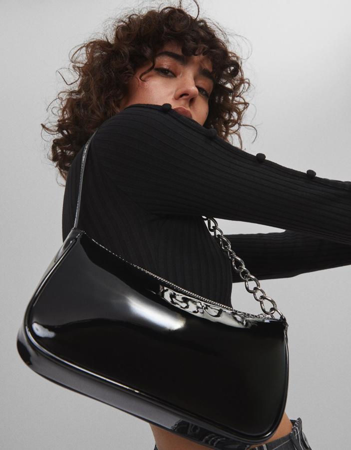 De charol y con asa de cadena, este bolso baguette es de Bershka y nos encanta tanto para el día como para la noche (15,99 euros).