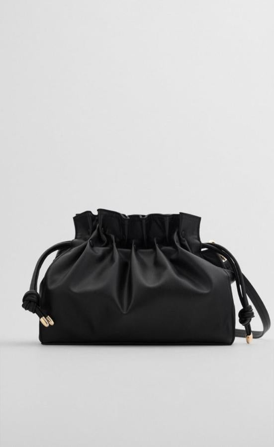 Bolso negro con forma de saco que se ajusta en la parte del cierre y se puede llevar como bolso de mano o colgado, de los Special Prices de Zara (15,99 euros).