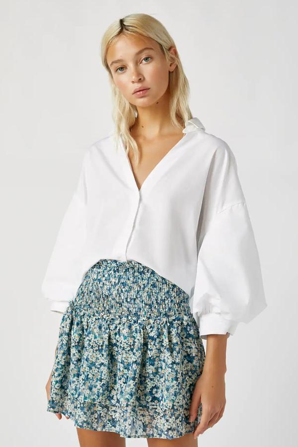 Disponible en tonos azules o arena, esta minifalda con cintura elástica y bajo acabado en volante es de Pull & Bear y tiene un precio de 22,99 euros.