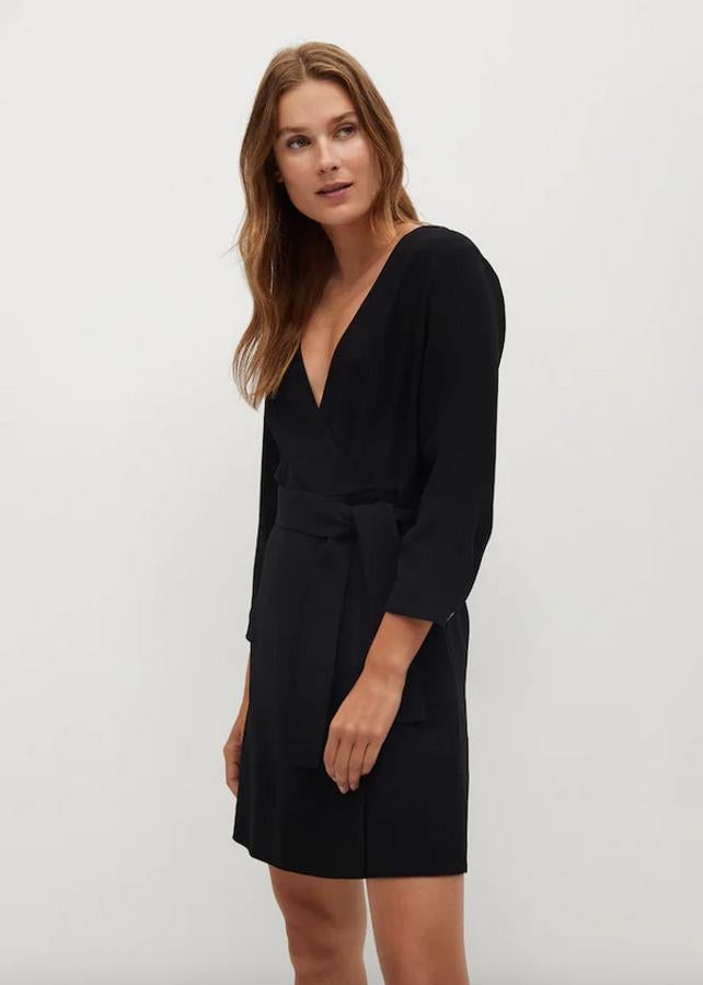Con escote de pico cruzado y cinturón extraíble a tono, este vestido mini negro de Mango pertenece a la colección sostenible de la firma y está disponible entre las tallas XS y XL por 29,99 euros.