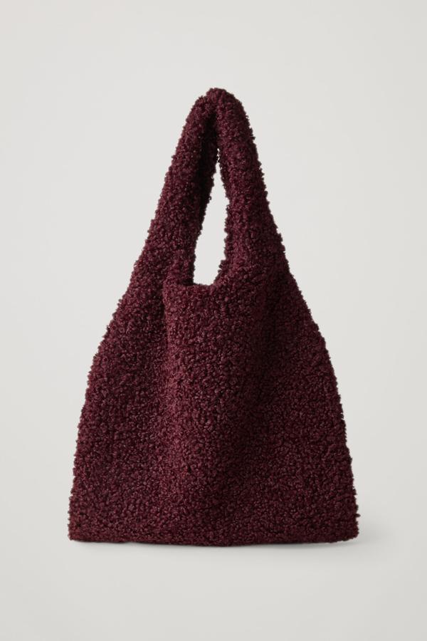 Saco XL de pelo rizado en tonos burdeos, de COS (99 €).