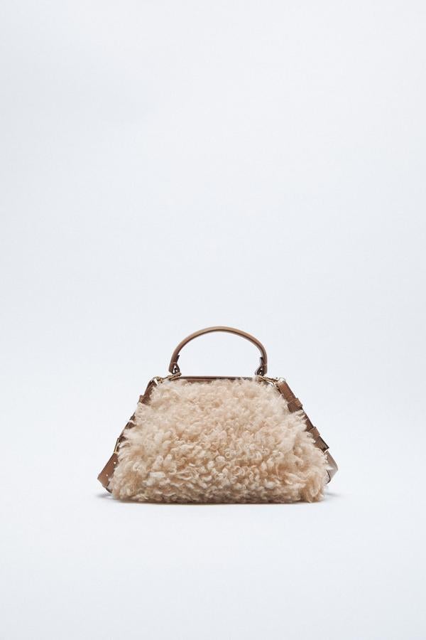 Bandolera de cuero y borreguillo rizado con cierre rígido y asa corta, de Zara (35,95 €).