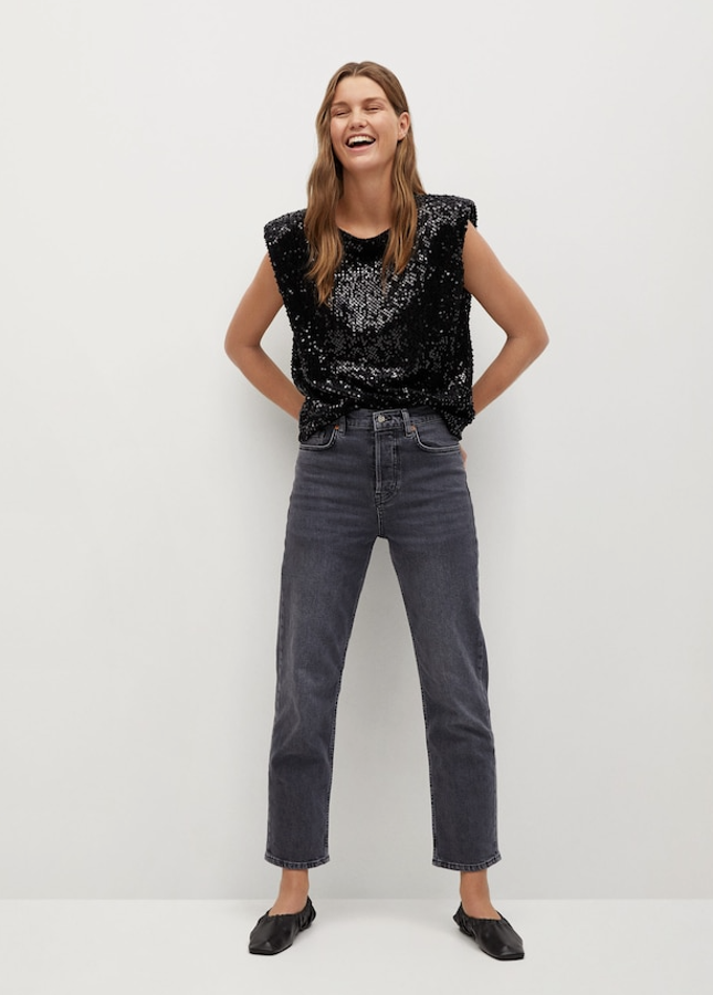 Nos gusta especialmente este look: qué gran idea combinar unos vaqueros en denim lavado con lentejuelas negras, Pero, además, nos encanta que Mango lleva a la fiesta la deseadísima camiseta sin mangas y con hombreras (29,99 euros). Atención a las bailarinas de piel fruncida, rebajadas ahora mismo de 39,99 euros a 29,99 euros. Terminan un look absolutamente perfecto.