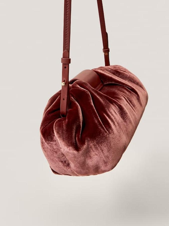 Disponible en cobre rosa o negro, este pouch aterciopelado tiene correa de hombro ajustable y forro interior. Cuesta 79,95 euros.