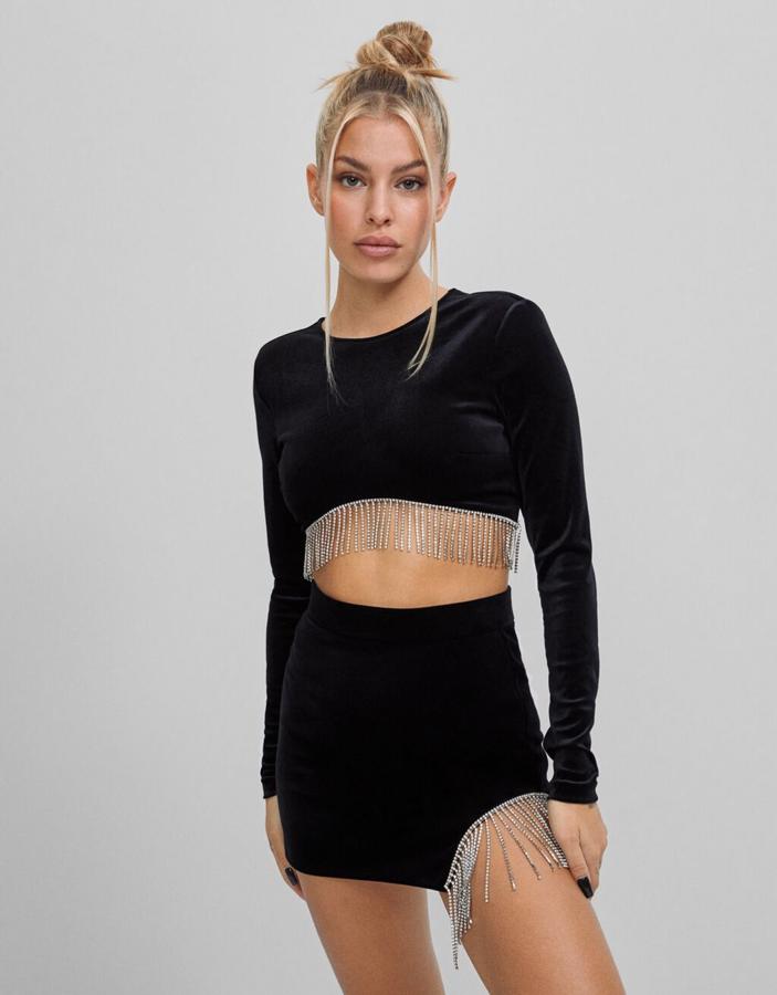 Top de tercipelo con flecos de strass (22,90 €) y falda de terciopelo con flecos de strass (25,99 €), todo de Bershka.