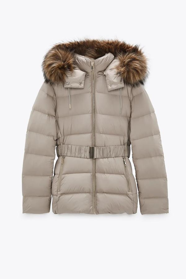 Este plumífero con relleno de pluma y plumón cuenta con aplicación efecto pelo desmontable en color toffe y cinturón elástico con hebilla metálica. Es de Zara y está rebajado, ahora tiene un precio de 39,99 euros.