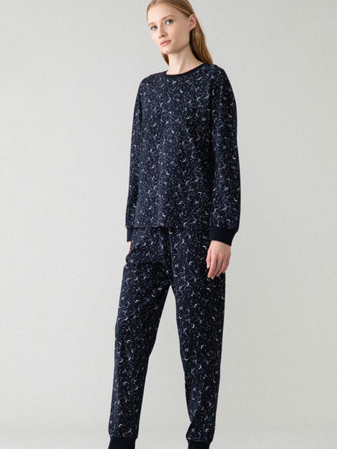 En color azul marino con estampado de pequeños dibujos en blanco, este pijama con puños acabados en elástico de punto de canalé está confeccionado en 100% algodón y tiene un precio de 9,99 euros.