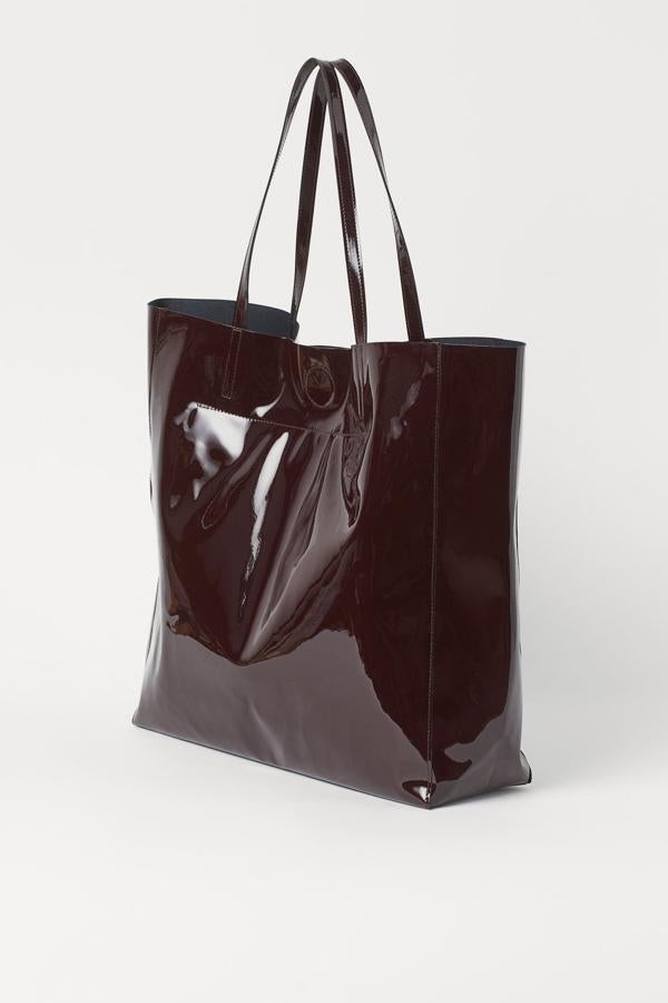 En color rojo oscuro, aunque disponible en otros tonos, este bolso shopper grande en piel sintética cuenta con dos asas y cierre magnético oculto. Es de H&M y tiene un precio de 19,99 euros,