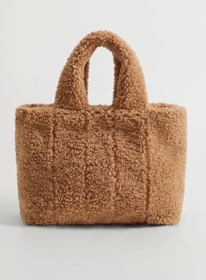 Este bolso shopper con tejido de efecto pelo en color beige (también está disponible en gris), cuenta con asa corta y asa larga desmontable. Es de Mango y tiene un precio de 29,99 euros.
