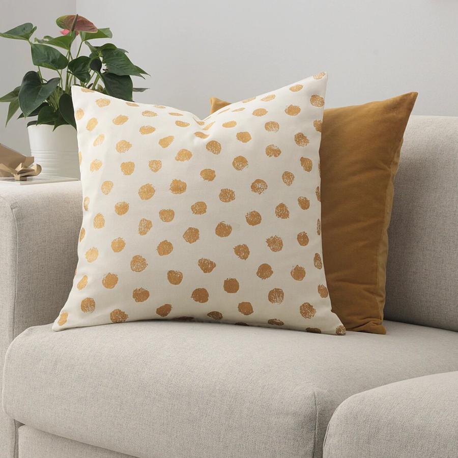 En color blanco roto con topos en dorado, esta funda de cojín con medidas de 50x50 centímetros tiene un precio de 5 euros.