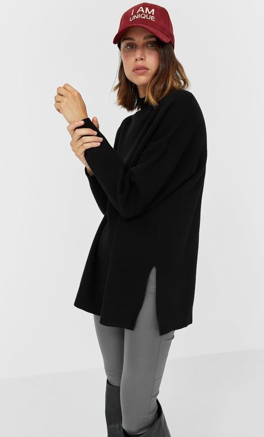 Con cuello perkins y detalle de abertura en los laterales, este jersey oversize en color negro, está disponible en otros tonos. Es de Stradivarius y tiene un precio de 25,99 euros