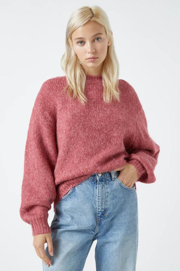 En color rosa oscuro o camel, este jersey oversize con hombreras y acabados en rib cuenta con cuello redondo y tiene un precio de 25,99 euros. Es de Pull & Bear.