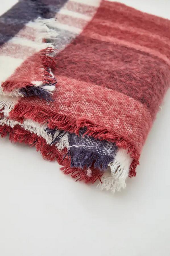 Con acabados desflecados y cuadros en tonos rojos, azules y blanco, esta bufanda es de Pull&Bear y tienen un precio de 12,99 euros.