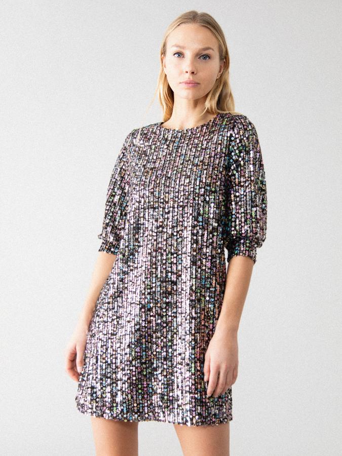 Lentejuelas multicolor sobre fondo negro para este vestido de corte recto, manga hasta el codo y cuello redondo. Cuesta 22,99 euros y está disponible en las tallas S, M y L.