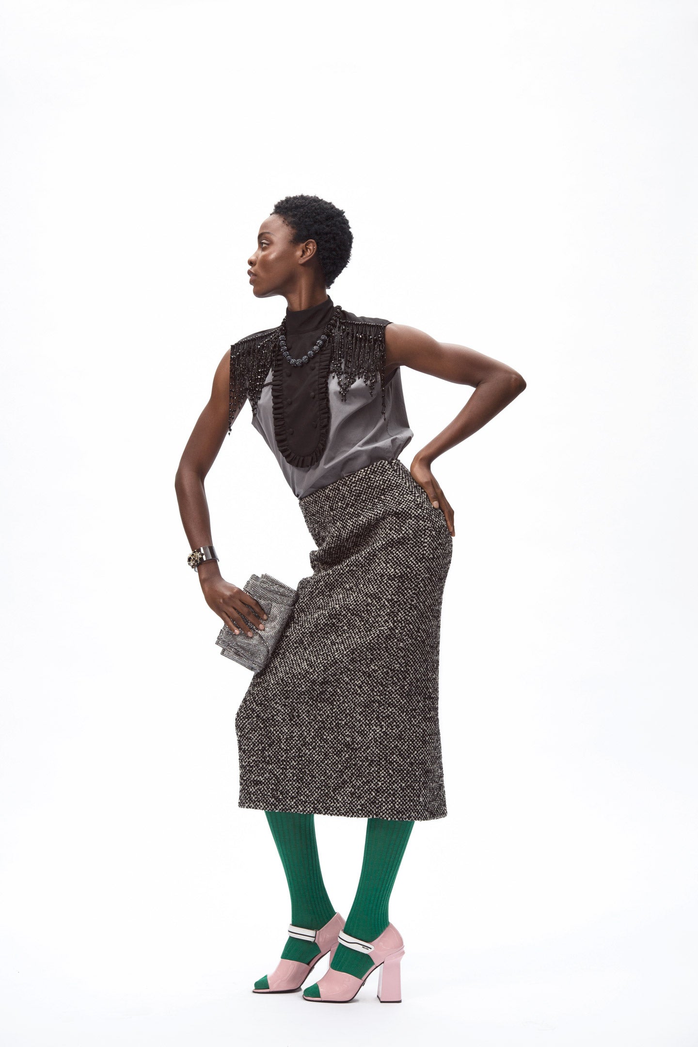 Top de seda con cuentas bordadas, falda, medias y zapatos, todo de Prada. La cartera de mano es de Giorgio Armani, y la pulsera y el collar, de El Corte Inglés.