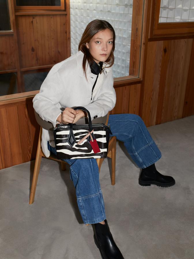 Formato tote para este bolso con estampado animal en tonos blancos y negros, cierre superior de cremallera y asas cortas de hombro en negro. De 32,99 euros ha pasado a costar 26,39 euros.