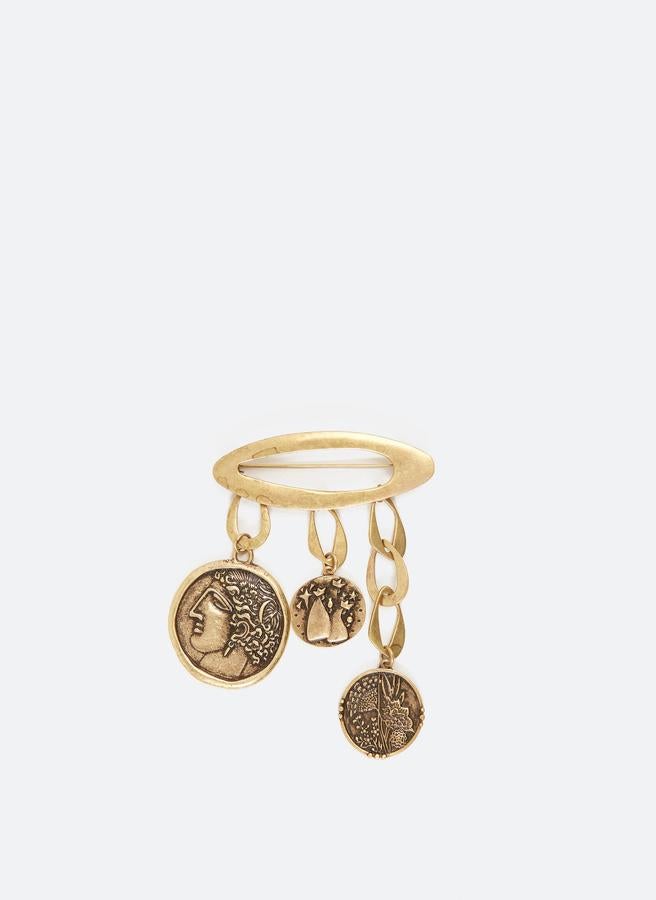 De forma ovalada y con adornos en forma de monedas antiguas, este broche dorado de Uterqüe tiene un precio de 39 euros.