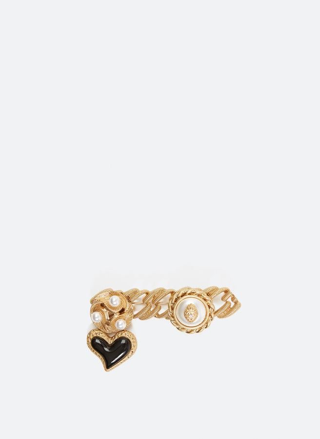Diseño horizontal con adorno tipo joya y perla para este broche que combina dorado, blanco y negro de Uterqüe. Cuesta 29 euros.