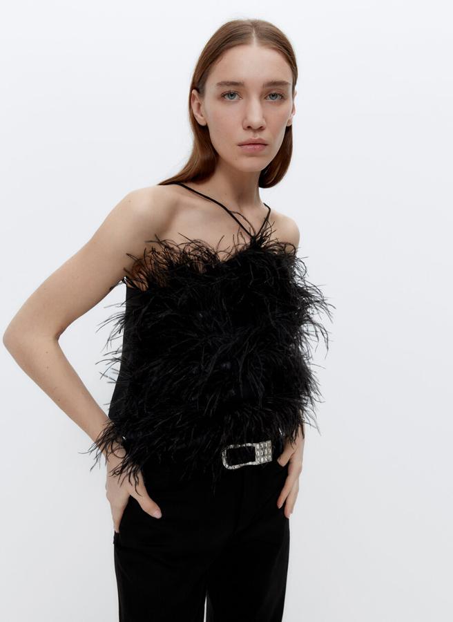 De escote halter con plumas en delantero, este top negro con tira en el cuello multiposición cuesta 129 euros y está disponible en las tallas S y M.