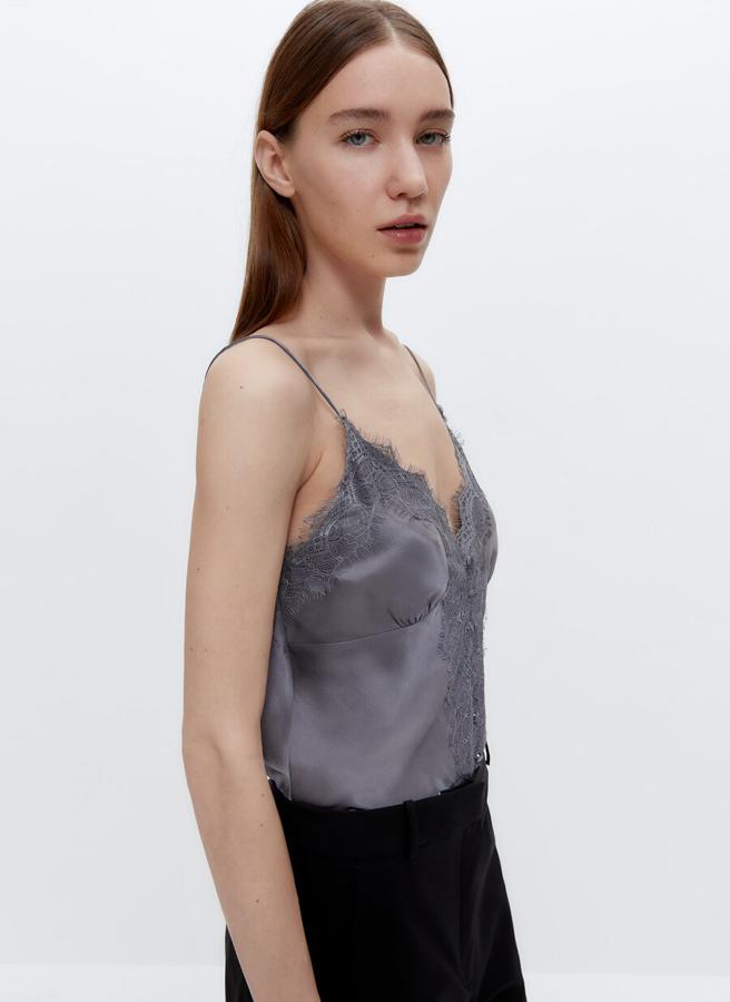 Con diseño de tirantes finos y puntilla en el escote y el centro del cuerpo, este top lencero en gris perla está disponible entre las tallas XS y L por 59 euros.