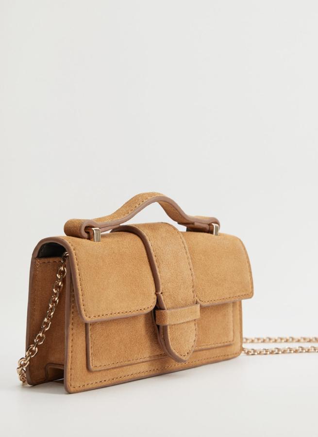 Este bolso mini, confeccionado en piel 100% bovina de color marrón cuenta con un asa corta y otra larga de cadena y tiene un precio rebajado de 20,79 euros. Es de Mango.