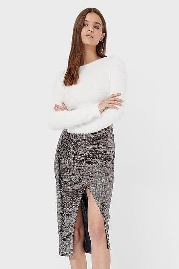 La falda, de corte midi, cuenta con una llamativa abertura en la parte delantera.