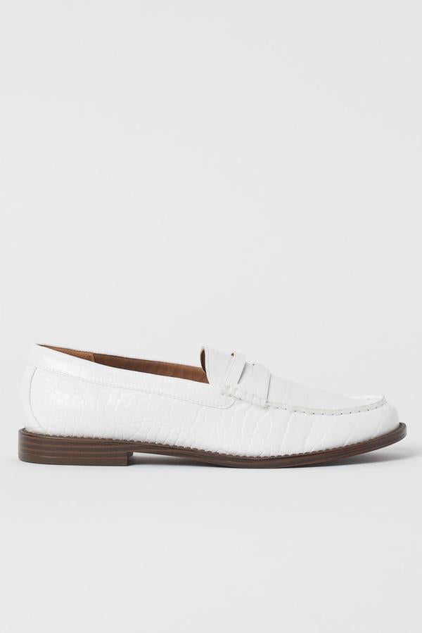 Parecen atrevidos, pero los zapatos y las botas blancas son un must de este otoño/invierno. Este modelo de H&M es troquelado y en acabado charol y tiene adorno de antifaz en la pala. ¡Ideales! (29,99 euros).