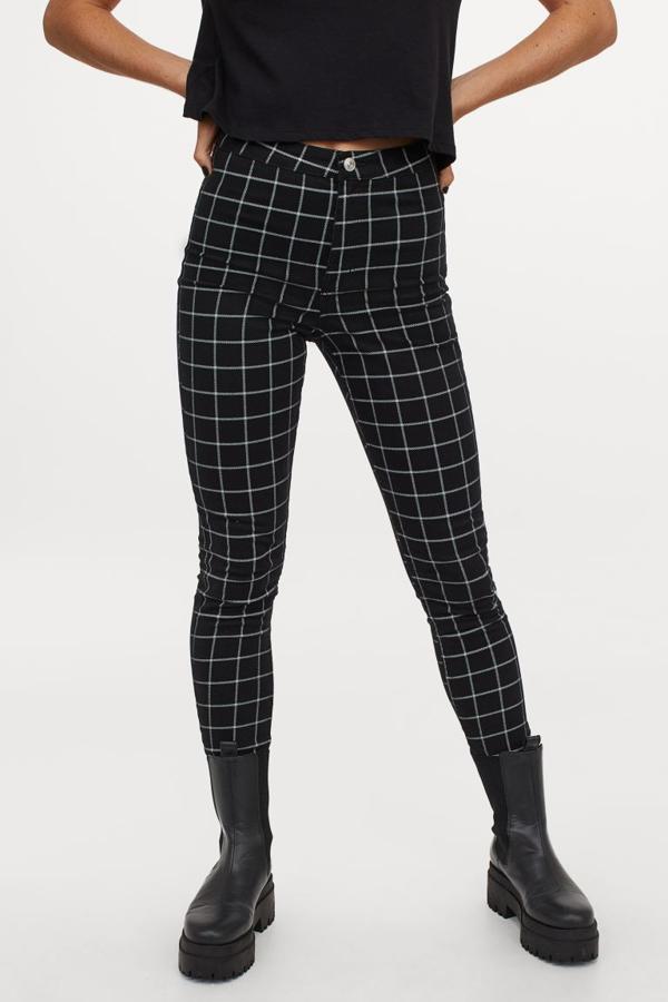 En sarga elástica de algodón, este pantalón tobillero de talle alto de H&M con perneras ajustadas en negro con cuadros blancos viene con bolsillos traseros y cierre de cremallera con botón. Cuesta 14,99 euros y está disponible entre las tallas 32 y 44.