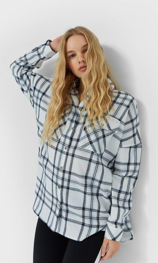 Fondo celeste con cuadros en dos tonos diferentes de azul para esta sobrecamisa de Stradivarius con cierre frontal de botones, cuello con solapa y bolsillos en el pecho con solapa. Disponible entre las tallas XS y XL, cuesta 19,99 euros.