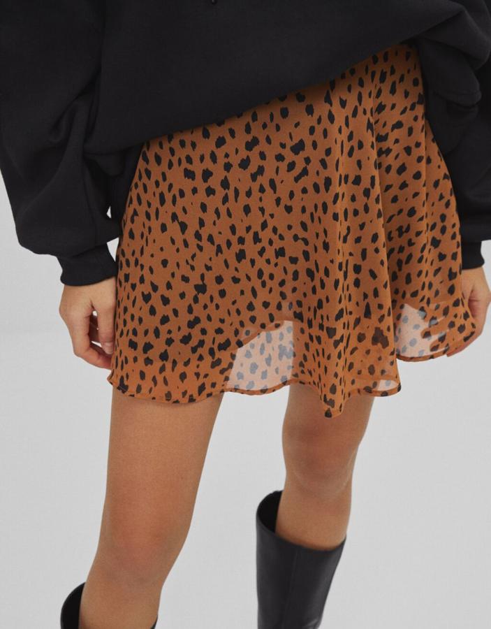 En camel con estampado a contraste en negro, esta falda mini skater de Bershka costaba 17,99 euros y ahora podemos comprarla por 10,79 euros entre las tallas XS y L.