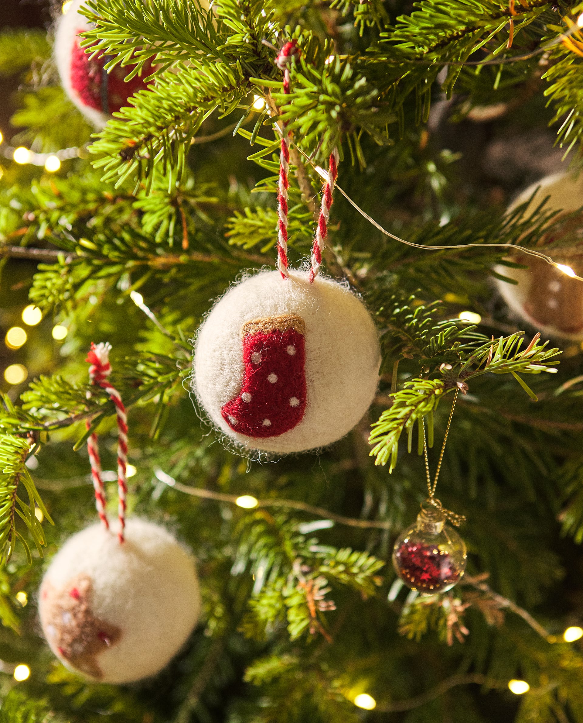 Estas originales bolas de fieltro con detalles navideños para tu árbol cuestan 4.99 euros en Zara Home.