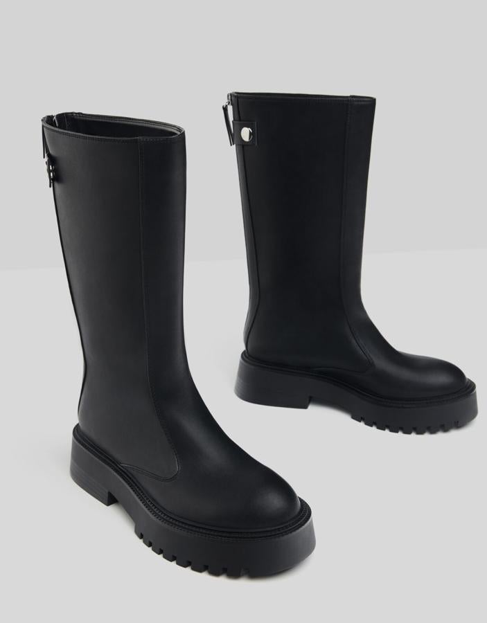 Con una plataforma de cuatro centímetros de altura, estas botas de media caña en color negro cuentan con suela track y cierre mediante cremallera trasera. Con detalle de botones, tienen un precio de 45,99 euros.