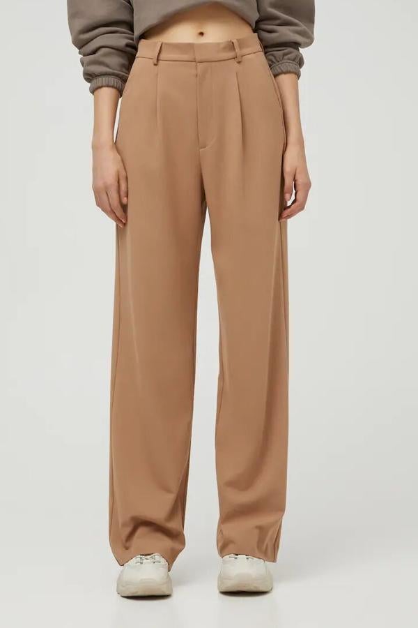 Disponible en beige, negro o gris, este pantalón básico de pinzas delanteras con cintura con trabilla es de Pull & Bear y tiene un precio de 22,99 euros.