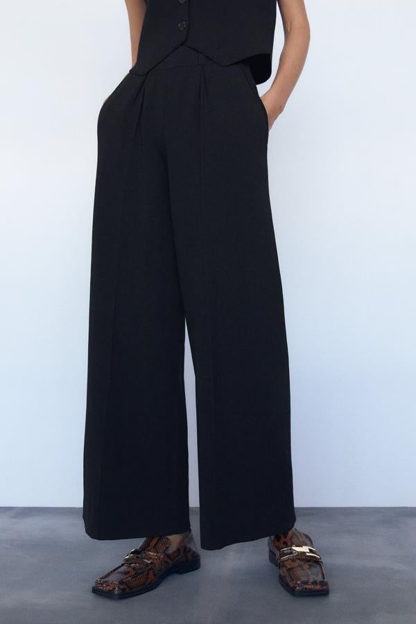 Este pantalón de tiro alto confeccionado en punto y con pinzas en la parte delantera cuenta con cintura elástica y pernera ancha. Con bolsillos delanteros, es de Zara y tiene un precio de 39,95 euros.