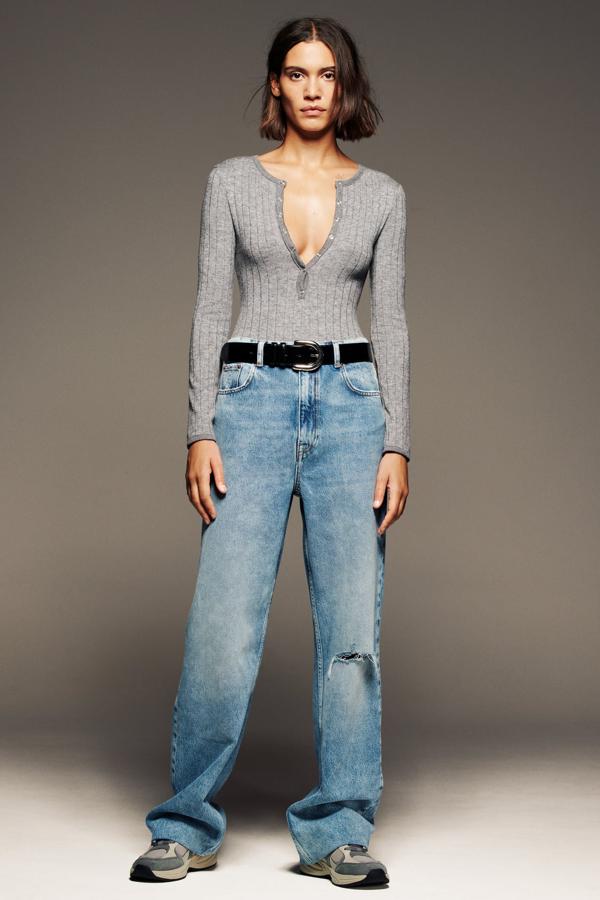 Camiseta de manga larga con escote de botones estilo panadero y vaquero recto con pernera rasgada, todo de Zara.