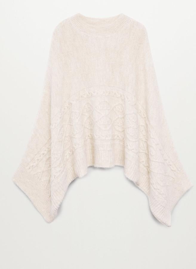 En tejido de punto de color crudo, esta capa oversize con cuello redondo y terminaciones de canalé es de Mango y tiene un precio de 39,99 euros.