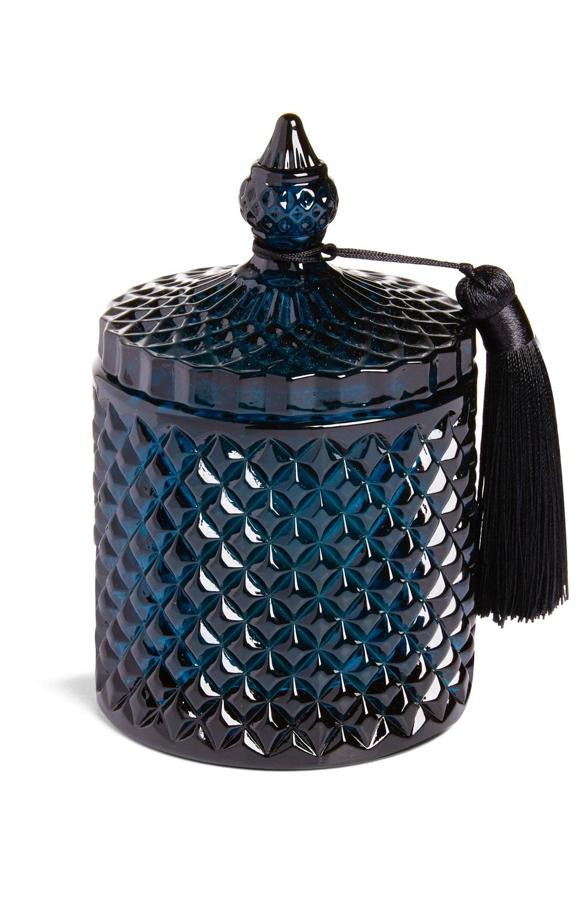 Esta vela, con recipiente de color azul oscuro con tapa y borla tiene un precio de 7 euros.