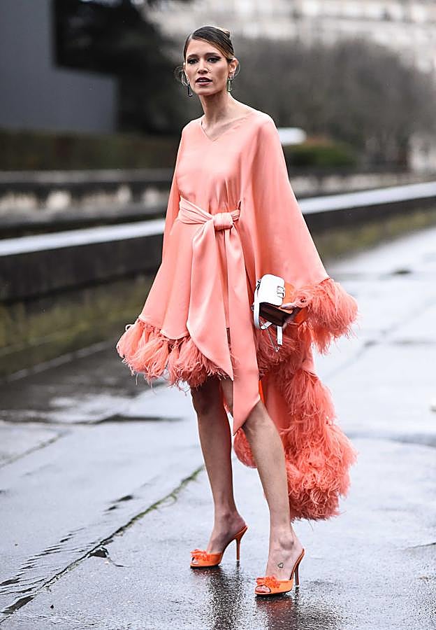 Vestido de raso asimétrico con manga larga en tonos coral.