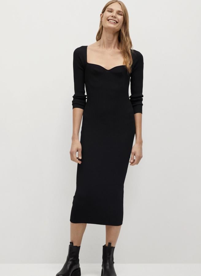 En tejido de canalé de color negro, este vestido negro con diseño entallado cuenta con cuello escotado y tiene un precio de 39,99 euros. Es de Mango.