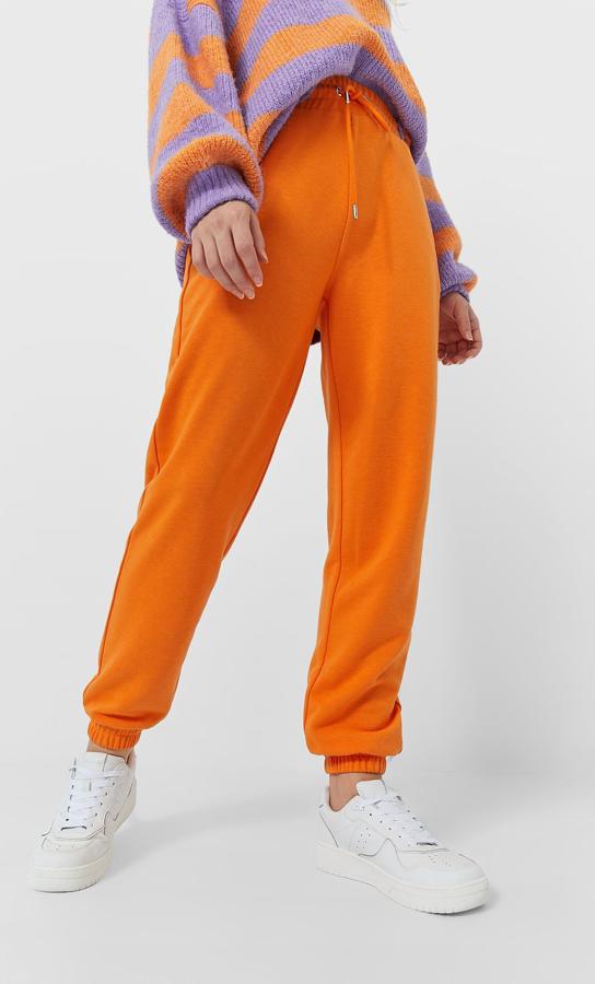 Este jogger de Stradivarius en color naranja es de tiro alto y tiene la cintura elástica con cordones ajustables. Con bajo acabado en puño, podemos encontrarlo en otros seis colores entre las tallas XS y XL por 12,99 euros.