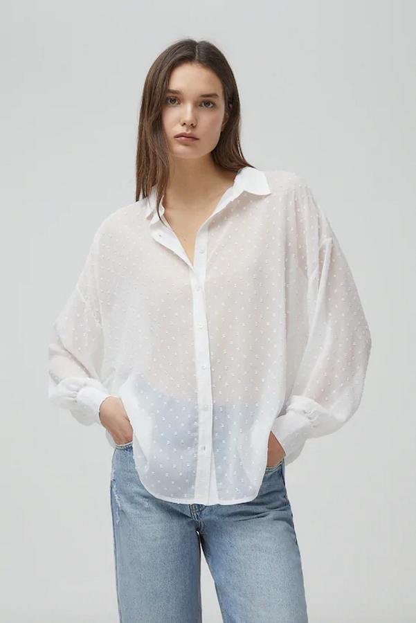 De venta exclusiva en la web de Pull&Bear, esta camisa blanca de plumeti puede convertirse en el comodín de nuestro armario porque es tan bonita como versátil. Con cierre de botones frontal y cuello clásico, cuesta 19,99 euros y está disponible entre las tallas XS y XL.