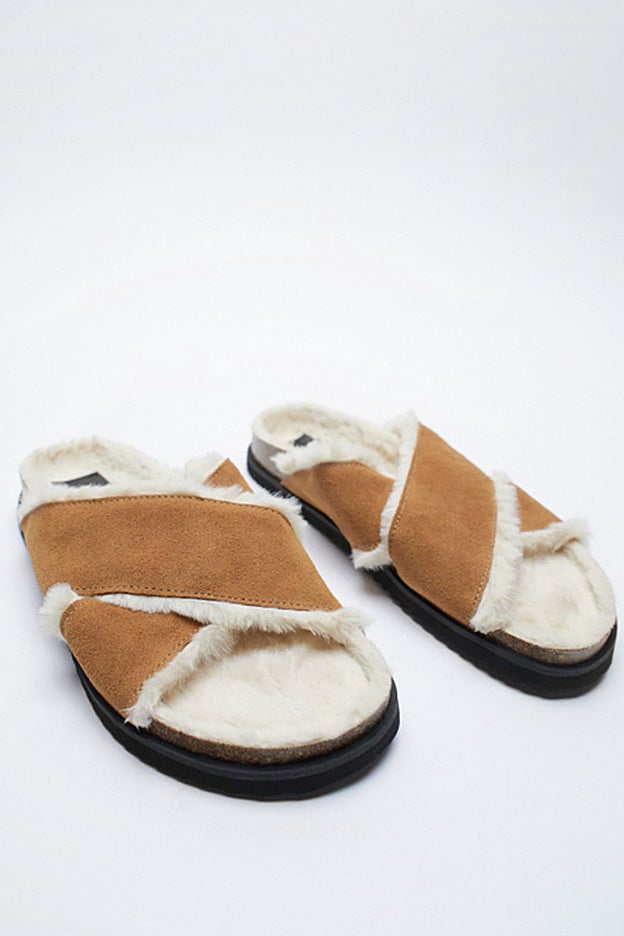 Sandalias planas de color cuero con tiras cruzadas y el interior de pelo.