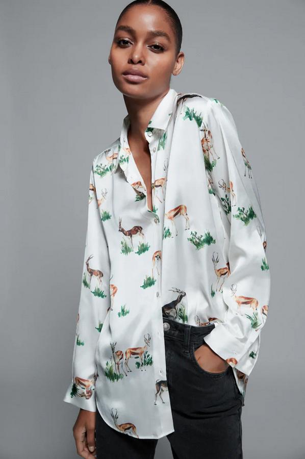 En crudo medio, con estampado de ciervos y hierba, esta camisa fluida de Zara con diseño satinado viene con cuello solapa y cierre frontal con botones. Cuesta 19,95 euros y está disponible entre las tallas XS y XL.